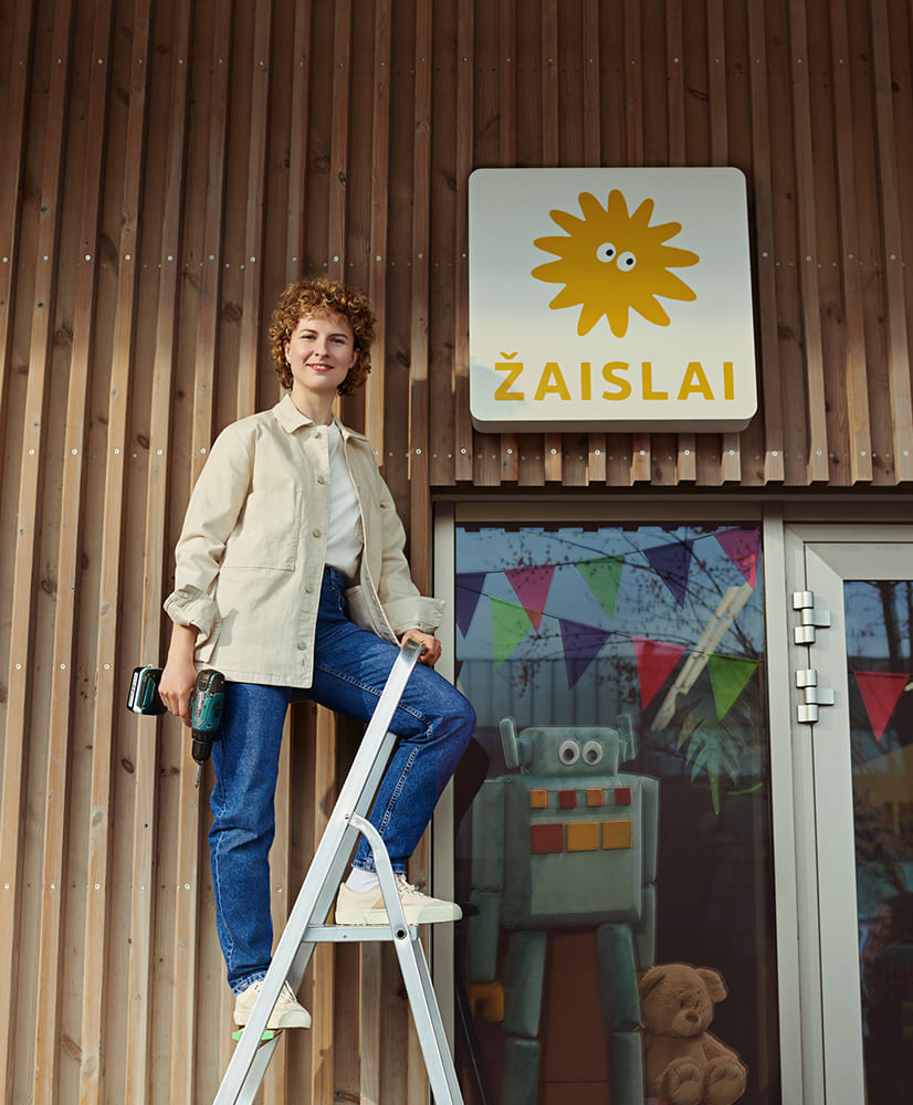 Žaislų parduotuvės savininkė kabina iškabą