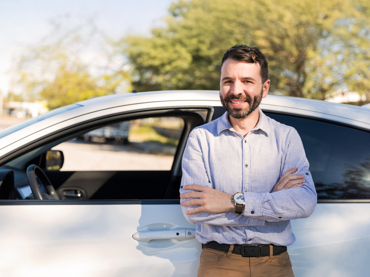 Vyras stovi prie automobilio džiaugdamas, kad dabar apsidraudė mašiną Kasko draudimu.