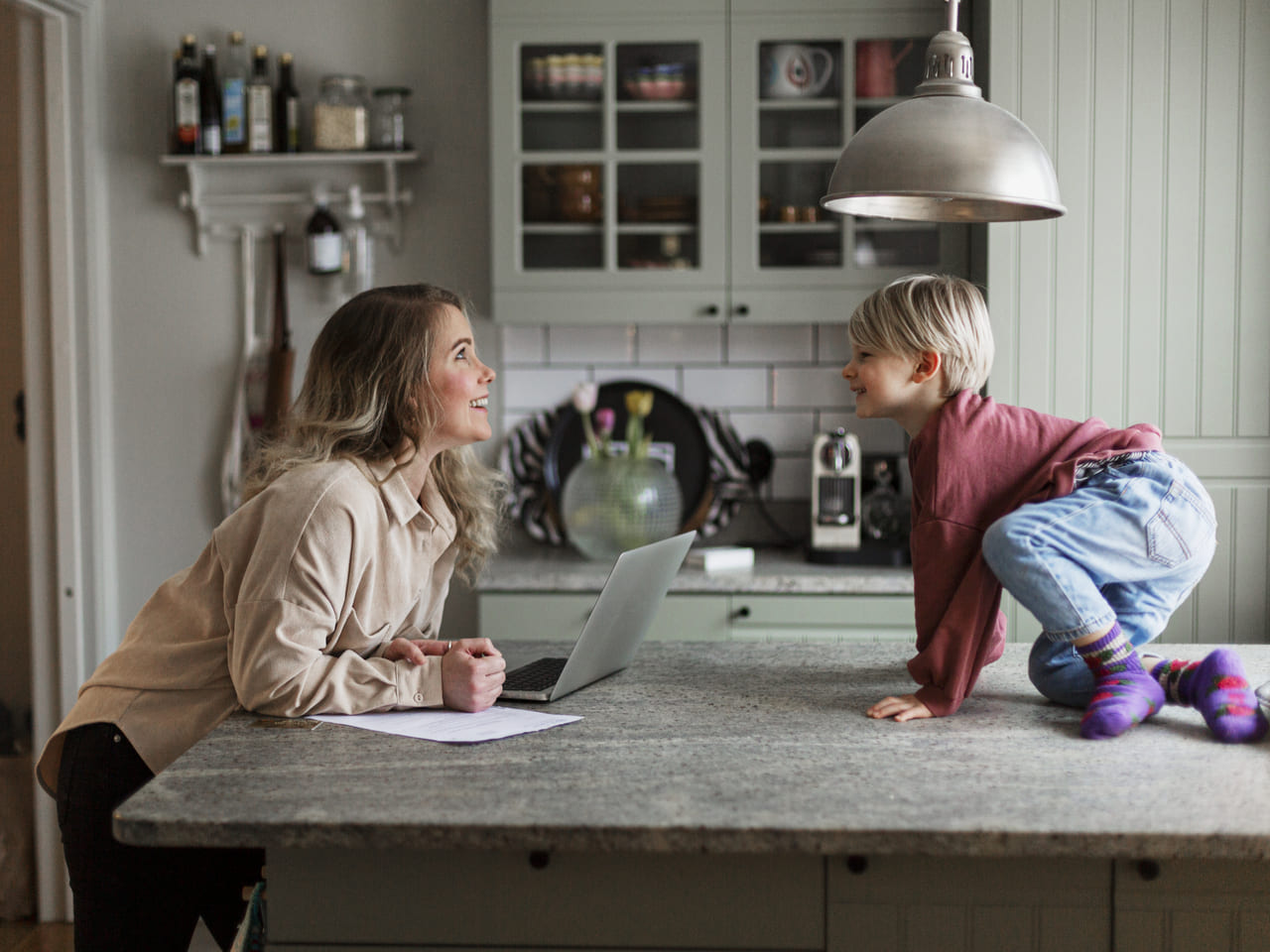 Du žmonės jaukioje virtuvėje leidžia laiką kartu, primindami apie būsto draudimo svarbą kasdienybėje.